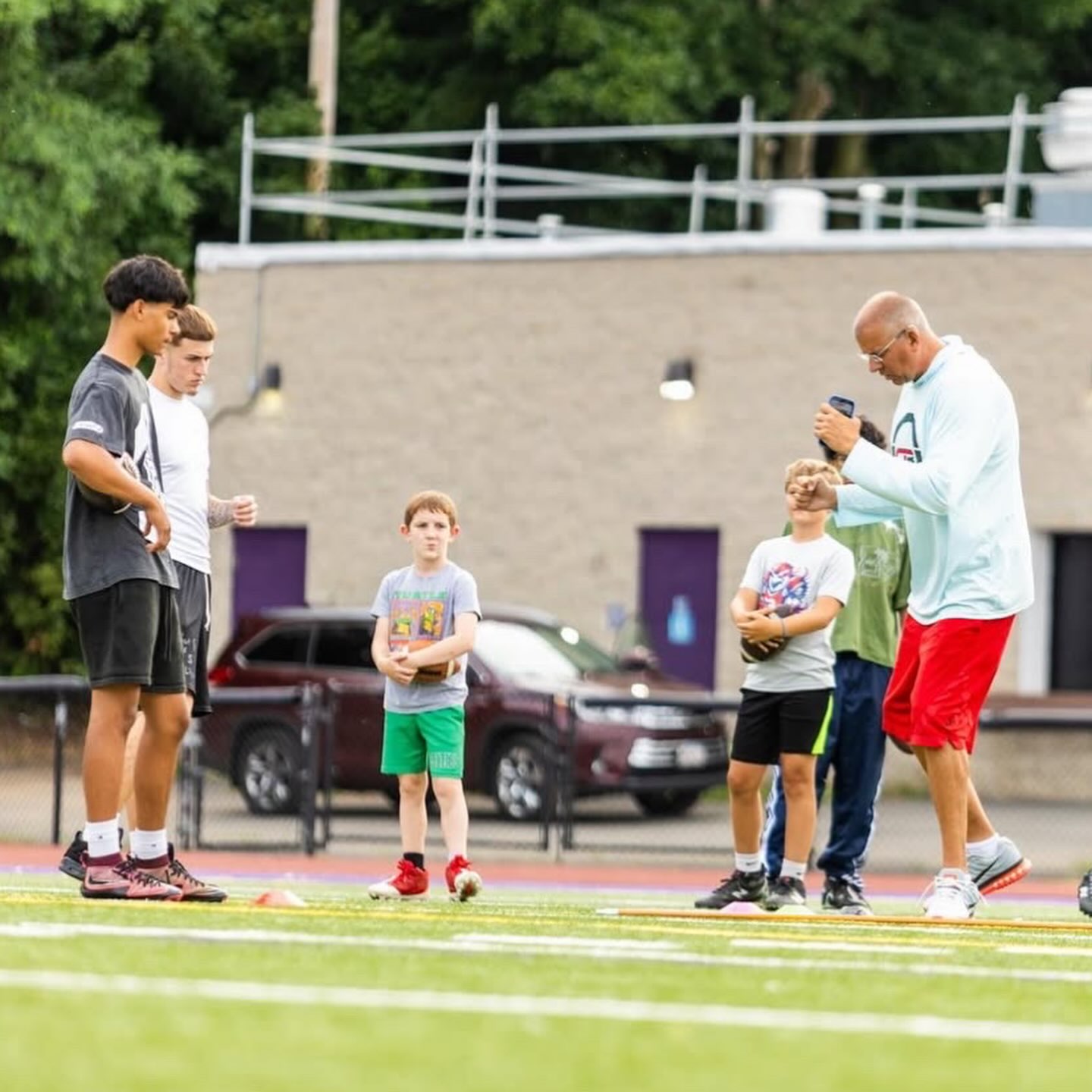 Craig demonstrating technique to a group of quarterbacks