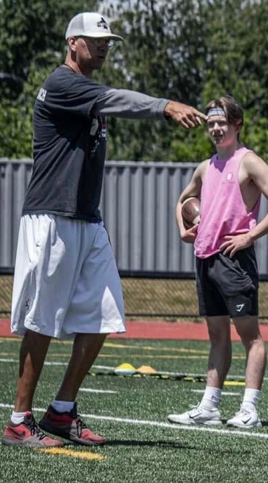 Coach Craig demonstrating technique during individual quarterback training